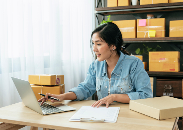 Online seller Close up hands Young asian woman typing laptop keyboard checking online order, check goods stock delivery package shipping postal. Asian woman startup small business at home office